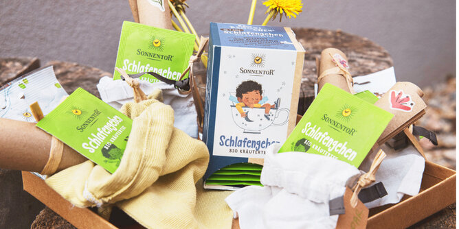 Schlafengehen | © SONNENTOR Auf dem Foto sieht man eine Packung Schlafengehen Tee. Daneben liegen die einzeln verpackten Teebeutel. | © SONNENTOR